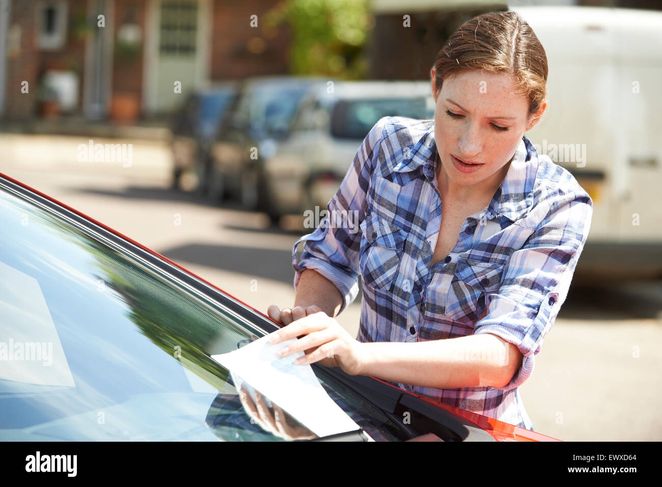 Frustrato automobilista femmina guardando i biglietti per il parcheggio Foto Stock