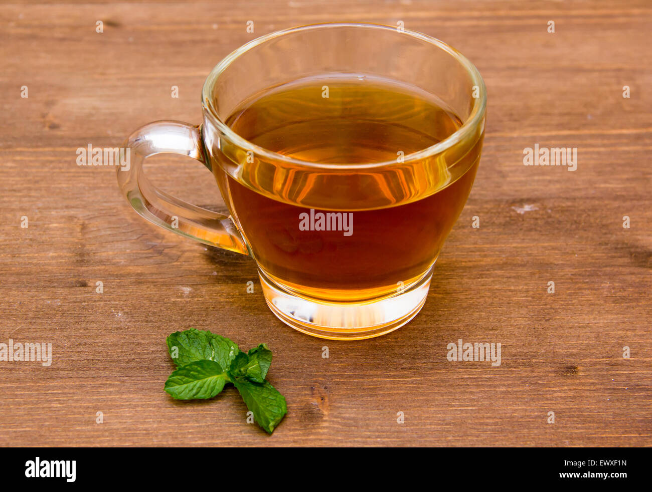 Il tè alla menta sulla tazza sul tavolo di legno Foto Stock