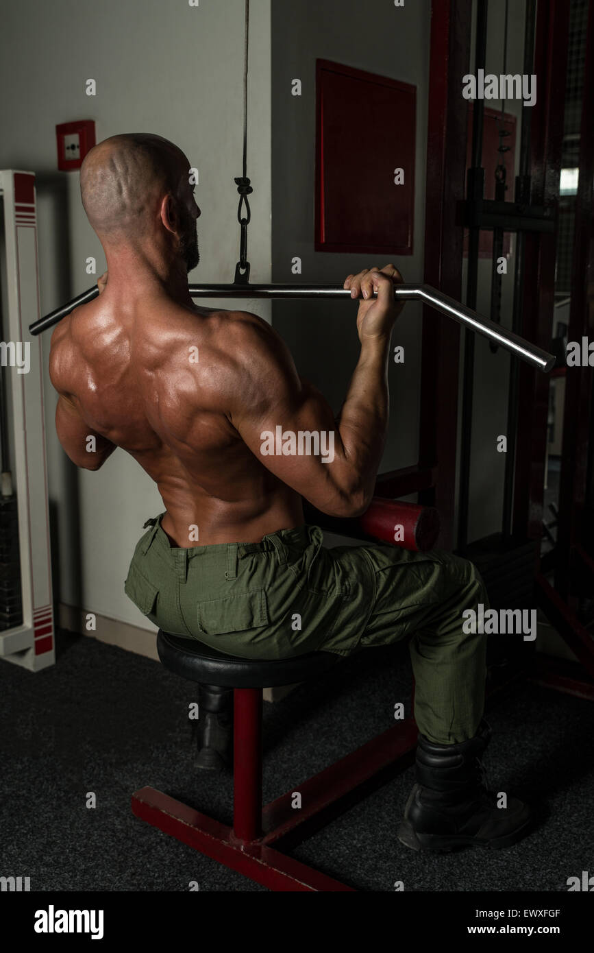 Uomo maturo facendo esercizi per la schiena in palestra Foto Stock