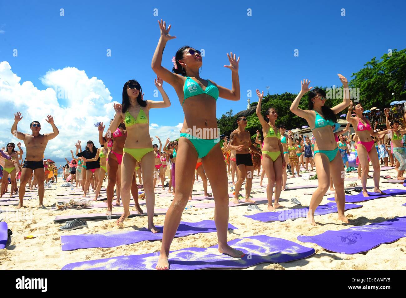 Pechino, Cina. 12 Luglio, 2014. Foto scattata a luglio 12, 2014 mostra gli appassionati di yoga la pratica dello yoga in bikini su una spiaggia di Sanya, Cina del sud della provincia di Hainan. © Chen Wenwu/Xinhua/Alamy Live News Foto Stock