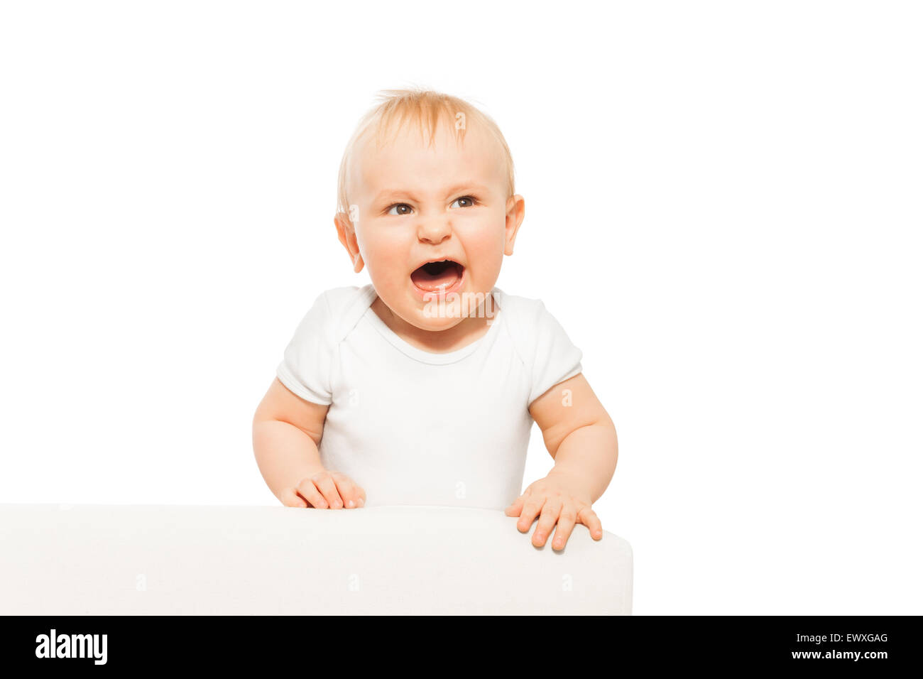 Arrabbiato piccolo bimbo con la bocca aperta in bianco body Foto Stock