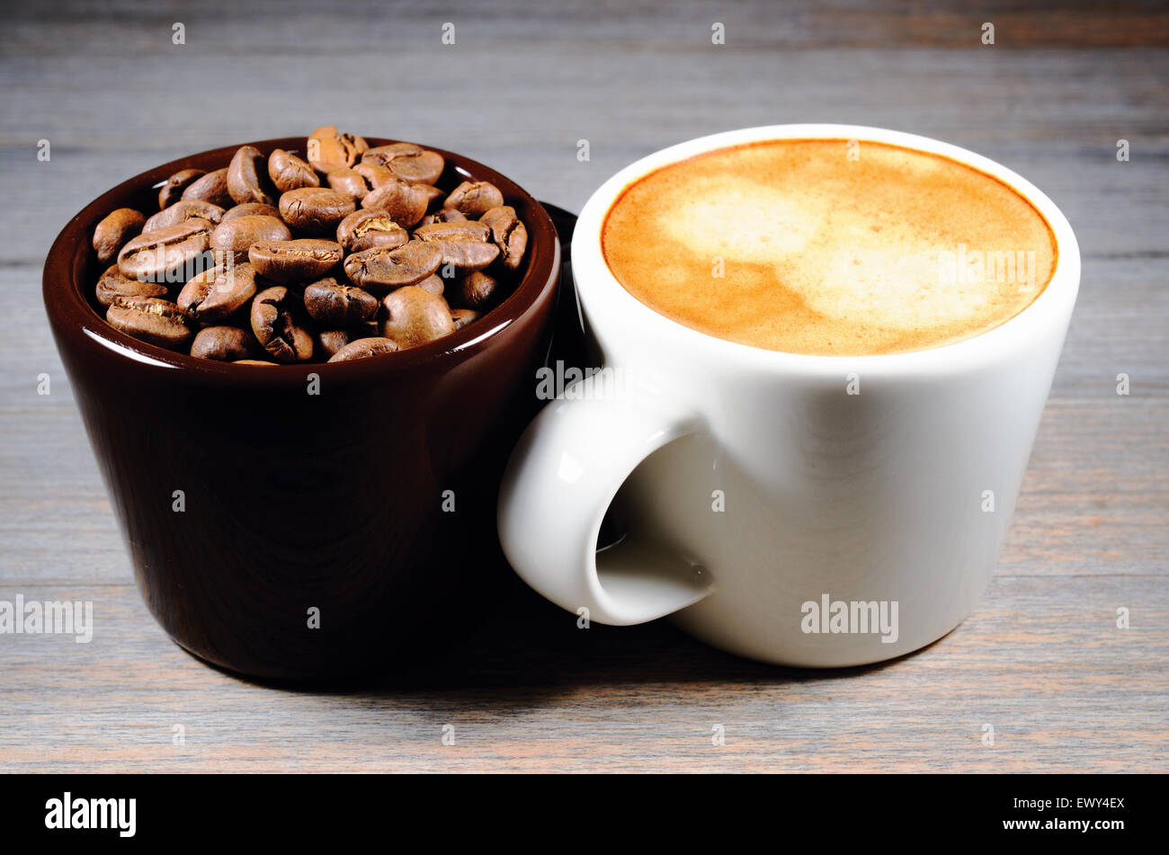 Espresso e la tazza di caffè in grani su legno Foto Stock