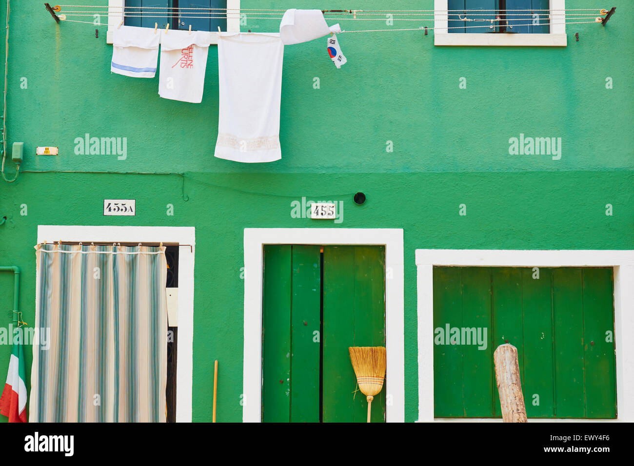 Spazzole di spazzamento una bandiera italiana e linea di lavaggio al di fuori di un dipinto di verde Casa Burano Laguna di Venezia Veneto Italia Europa Foto Stock