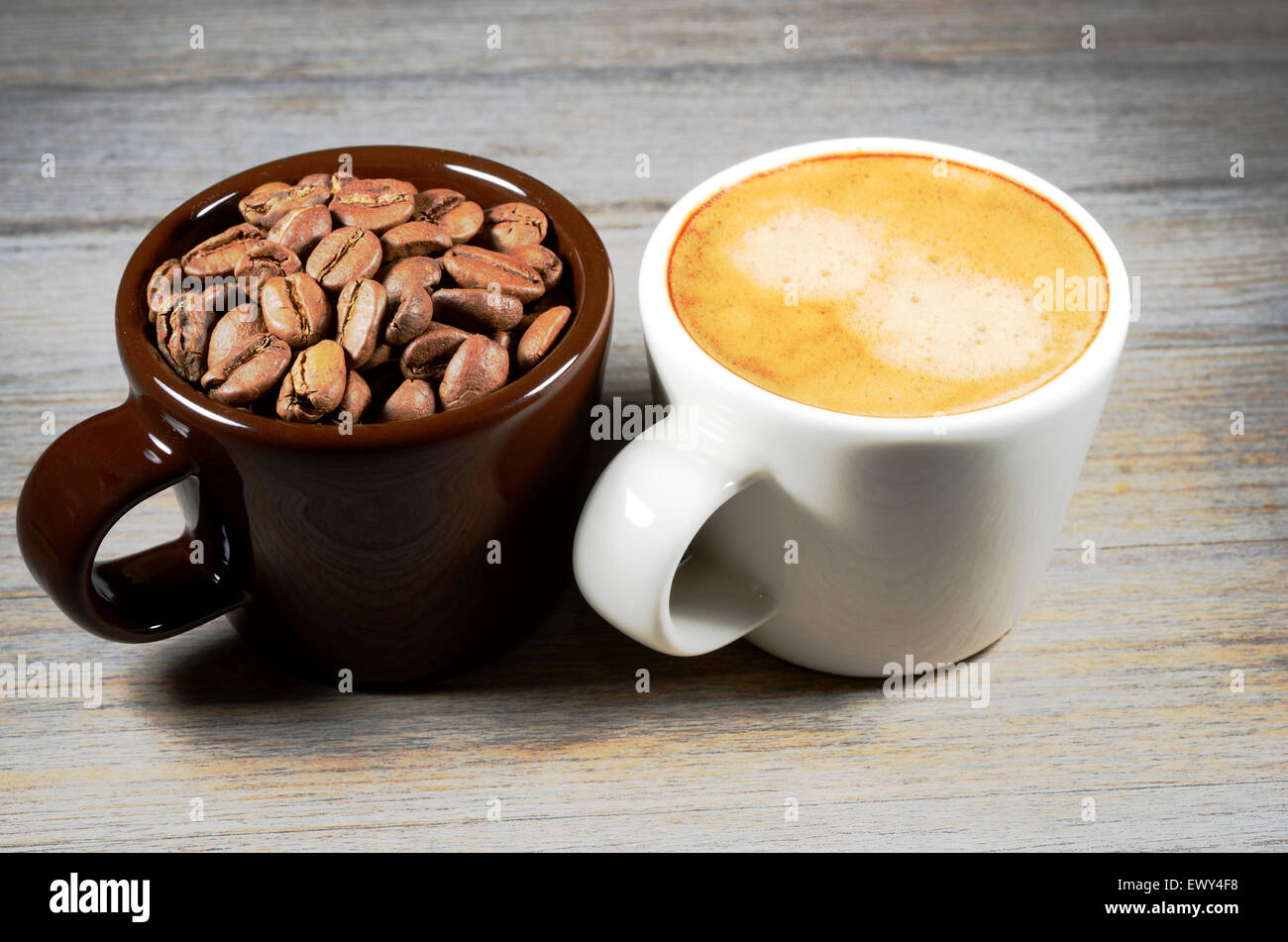 Espresso e la tazza di caffè in grani su legno Foto Stock