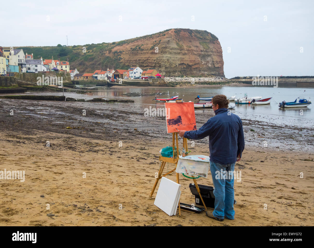 L'uomo pittura su Staithes beach durante Arts festival weekend. Staithes North Yorkshire, Inghilterra, Regno Unito Foto Stock
