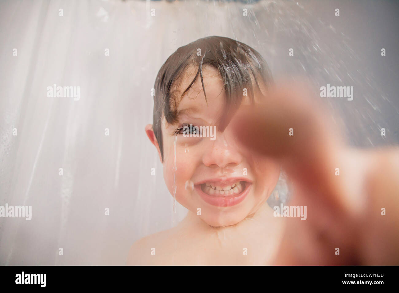 Ragazzo in piedi nella doccia che punta Foto Stock