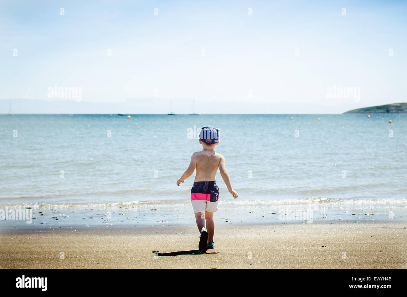 Ragazzo che cammina verso il mare Foto Stock