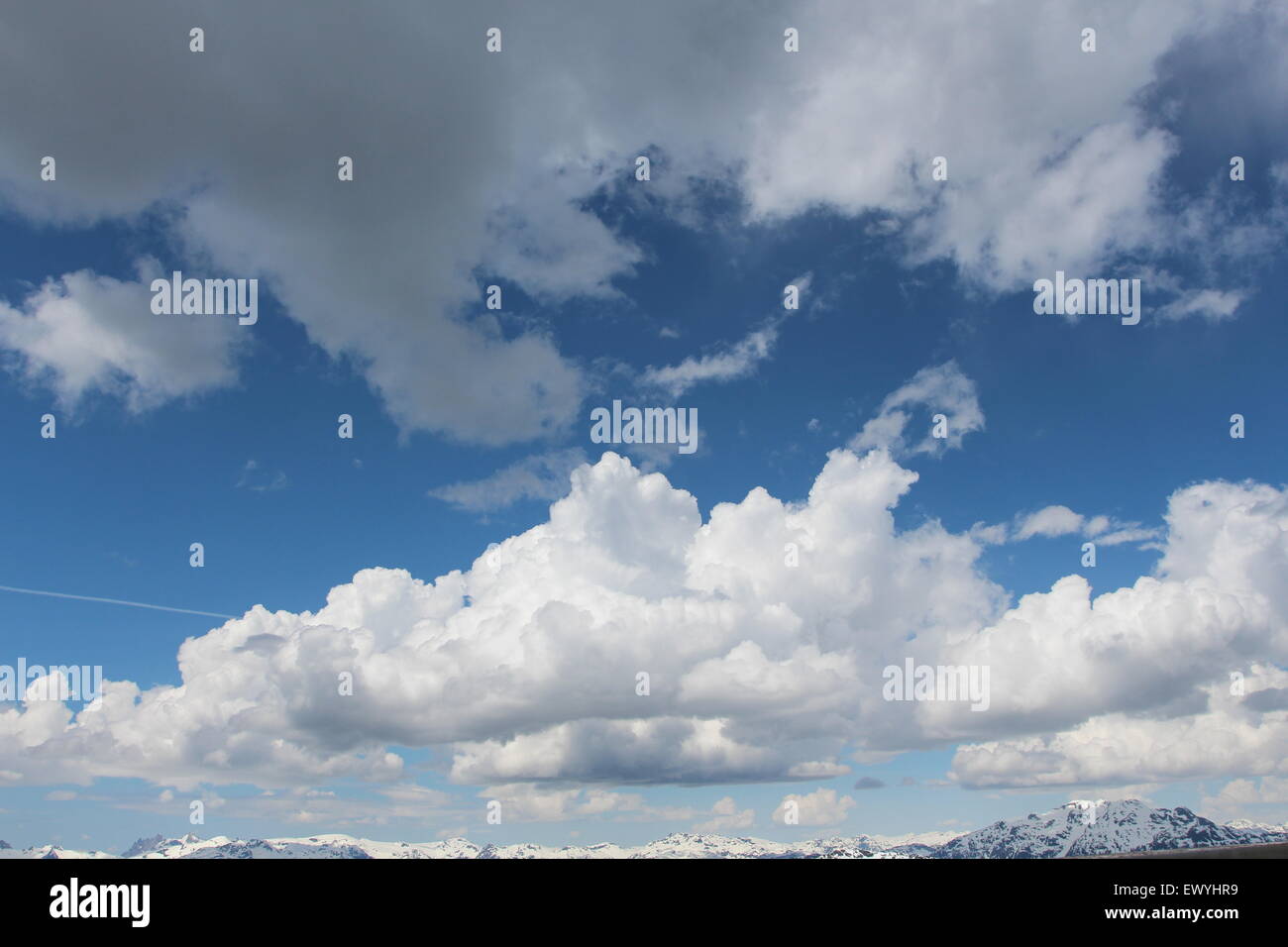 Il Cumulus bianche nuvole con uno sfondo blu cielo. muoversi sopra le cime delle montagne Foto Stock