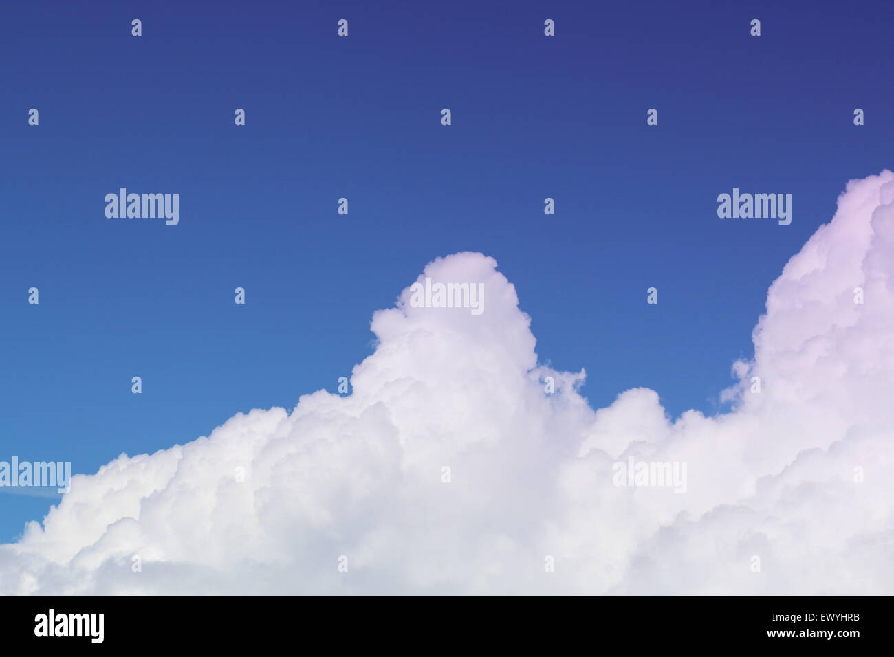 Il Cumulus bianche nuvole con uno sfondo blu cielo. muoversi sopra le cime delle montagne Foto Stock