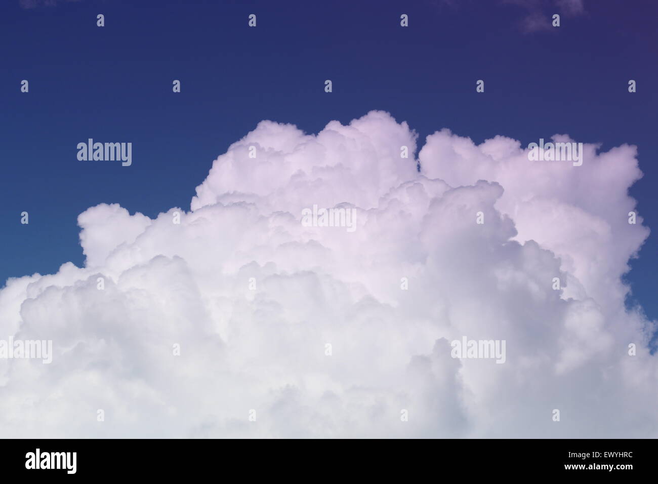 Il Cumulus bianche nuvole con uno sfondo blu cielo. muoversi sopra le cime delle montagne Foto Stock