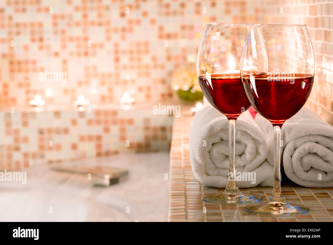 Due bicchieri di vino e candele accese close-up nella stanza da bagno Foto Stock