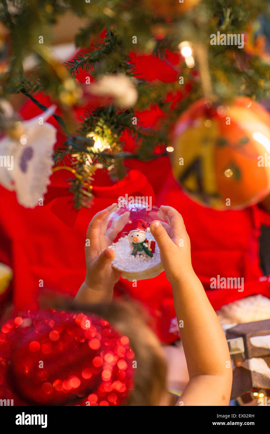 Bambina azienda snow globe ornamento in mano Foto Stock