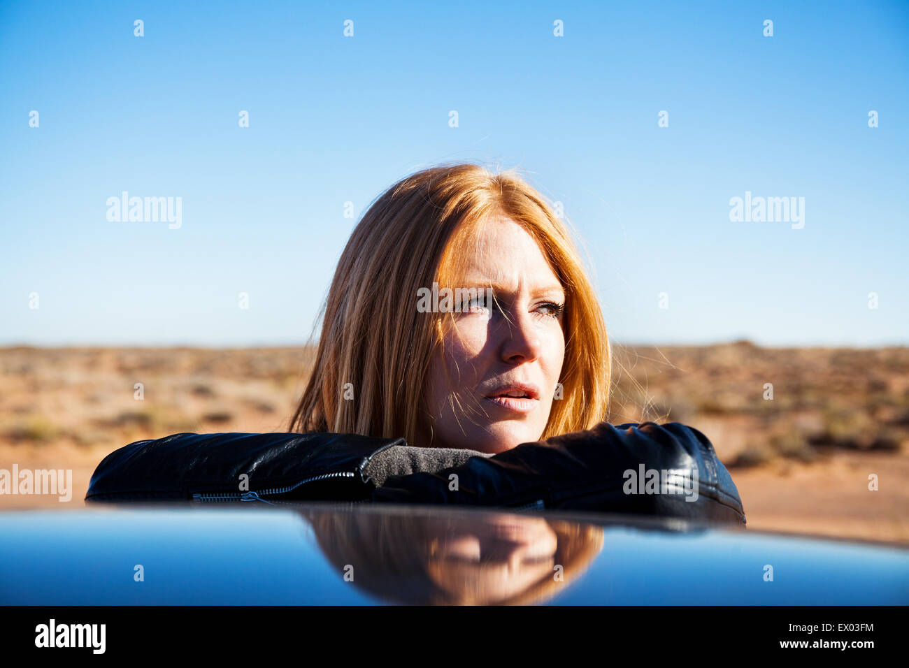 Donna appoggiata contro auto, Kayenta, Arizona, Stati Uniti d'America Foto Stock