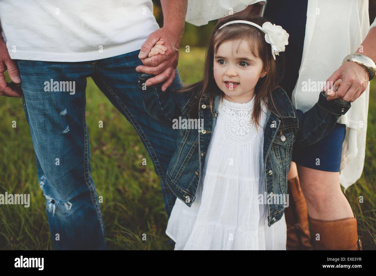 Giovane ragazza con i suoi genitori le mani, sezione bassa Foto Stock