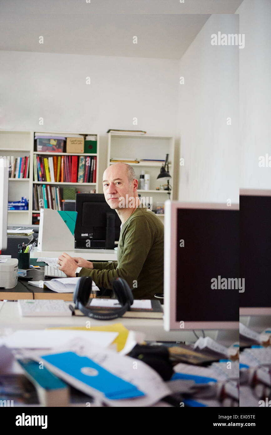 Uomo maturo al banco in creative studio, ritratto Foto Stock