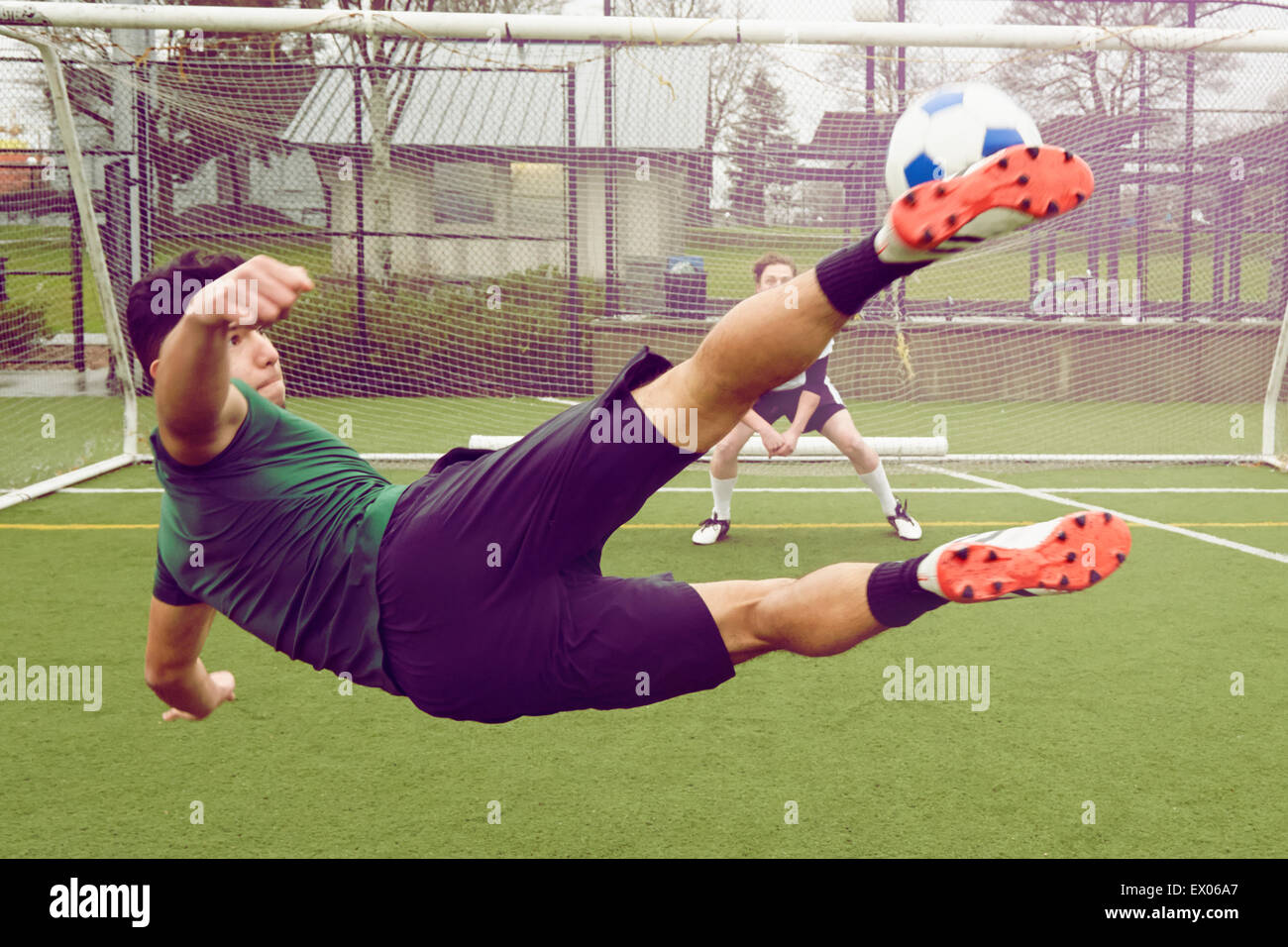 Maschio giovane giocatore di calcio calciare la palla verso la porta Foto  stock - Alamy