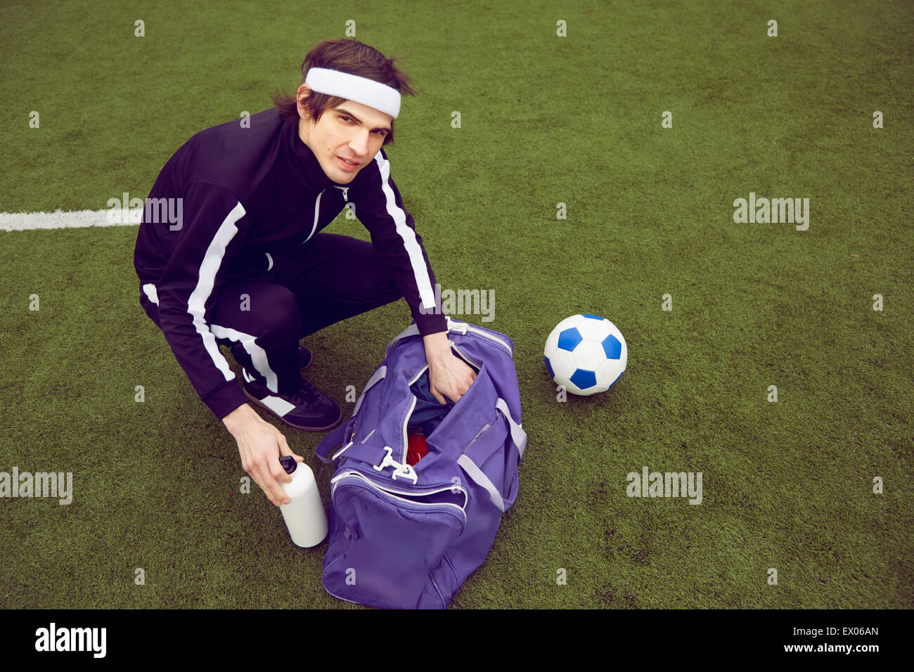 Maschio di giocatore di calcio si preparano a giocare sul campo di calcio Foto Stock