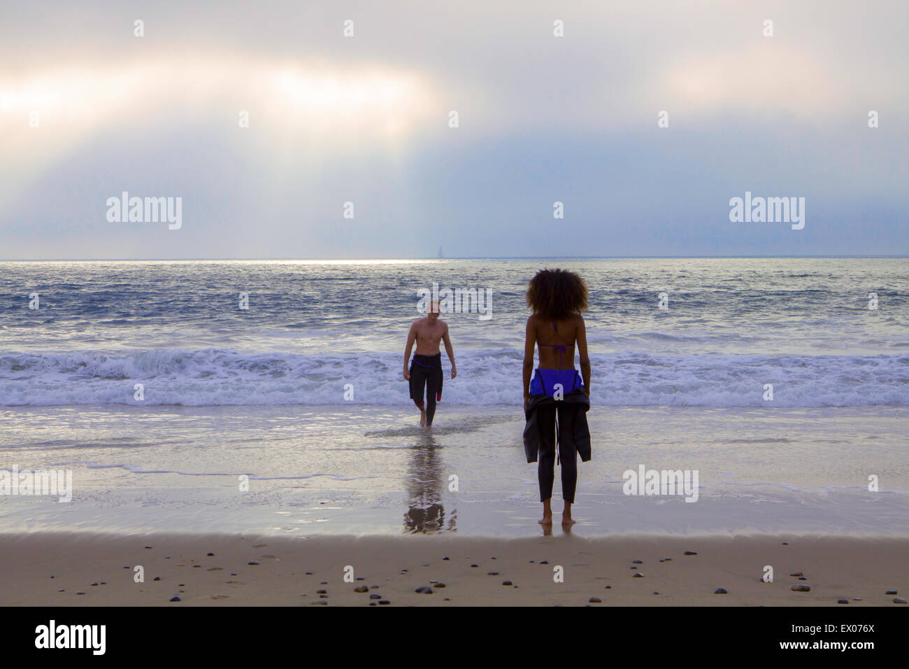 Giovane donna in attesa per il surf fidanzato sulla spiaggia Playa del Rey, California, Stati Uniti d'America Foto Stock