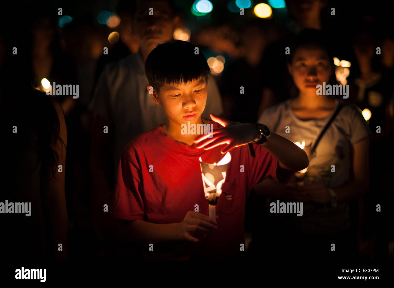 Un giovane ragazzo detiene una candela in una veglia a lume di candela per commemorare l anniversario del massacro di piazza Tiananmen Foto Stock