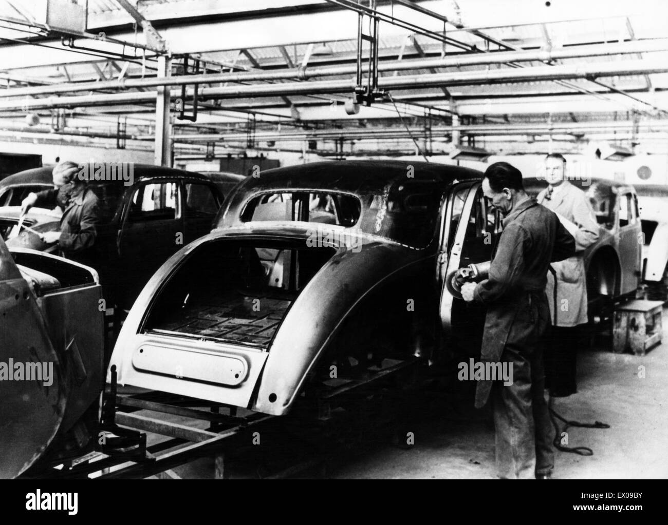 Produzione di Riley saloni nei tardi 1940s. Esperti artigiani sono visti di sbavatura e finitura dei corpi su linea di produzione prima del montaggio sul telaio in corrispondenza del Durbar Avenue fabbrica. Nel 1948 circa. Foto Stock