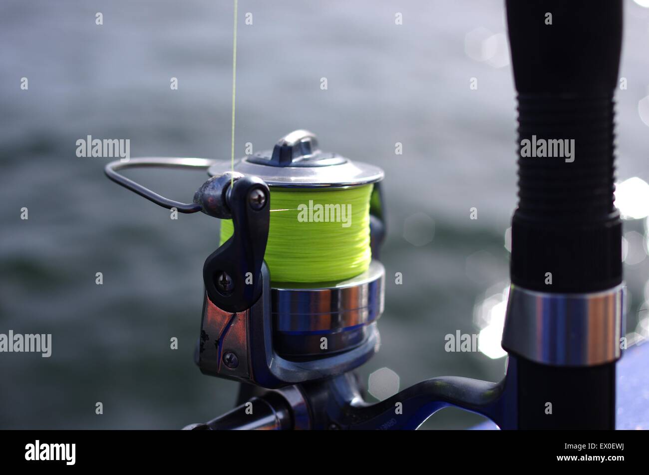 Canna da pesca a spinning-ruota su sfondo del mare Foto Stock