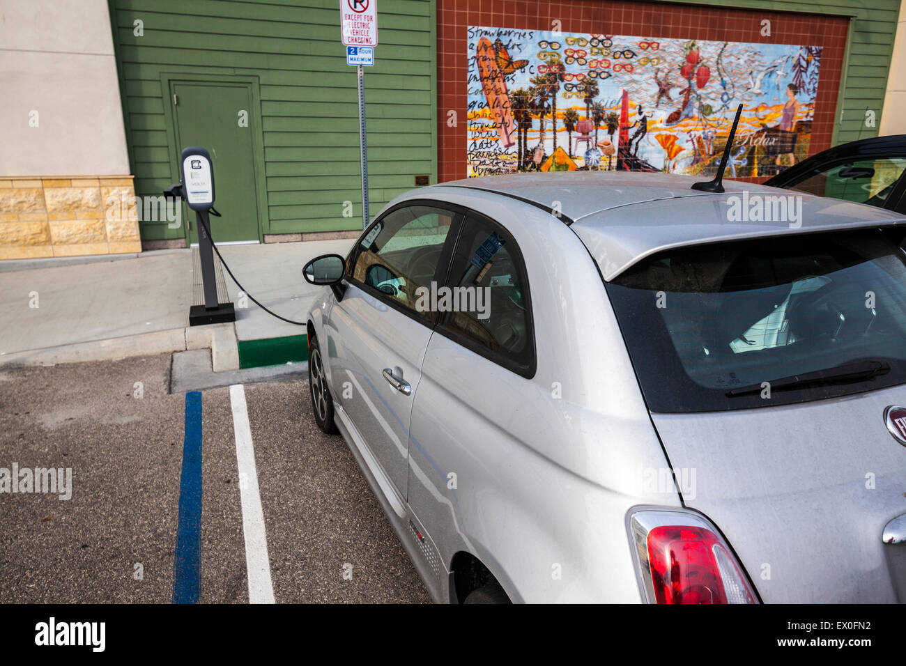 Una Fiat 500e auto elettrica in corrispondenza di una stazione di carica ad un centro commerciale di Oxnard in California Foto Stock