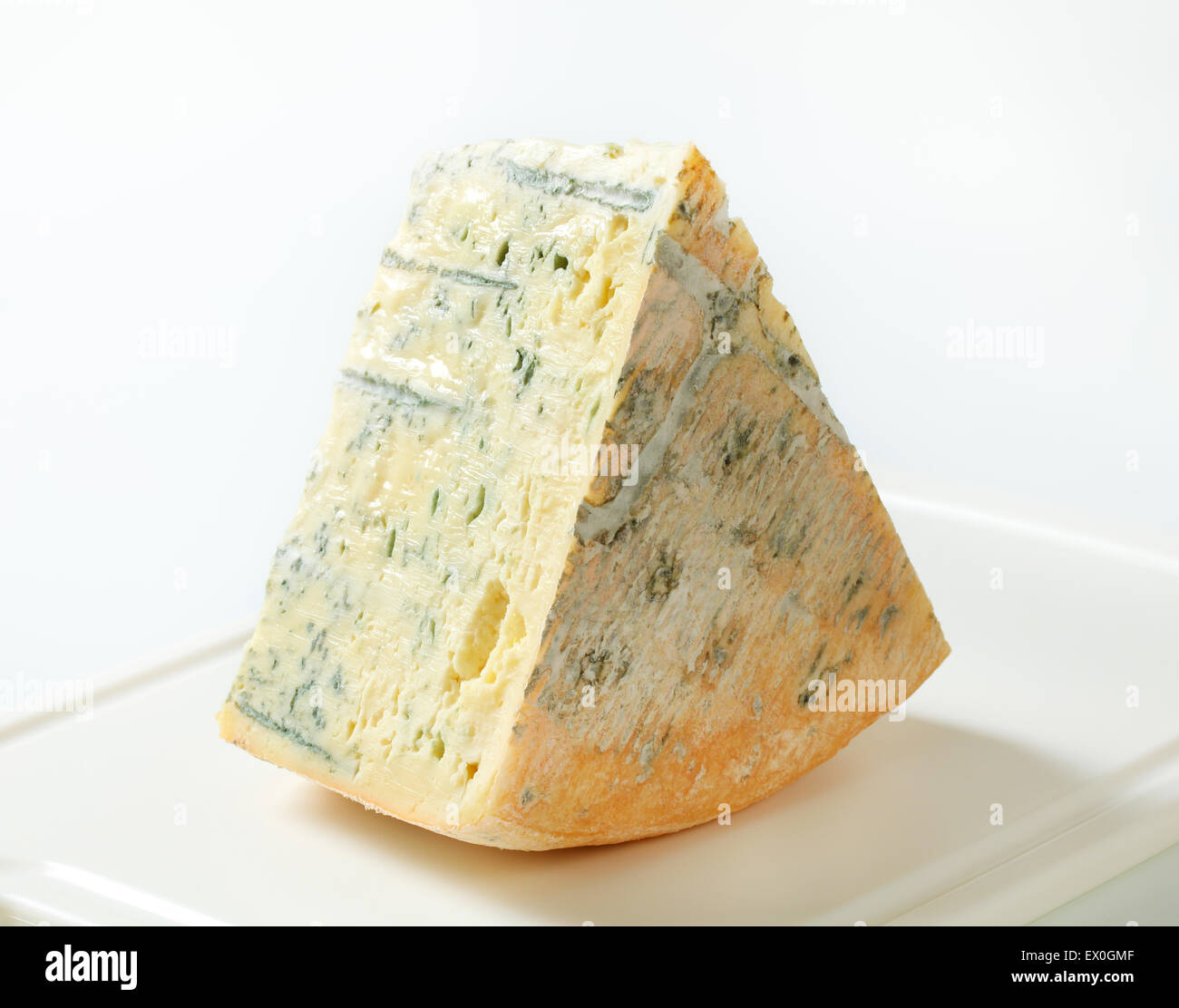 Grande fetta di formaggio blu su un tagliere Foto Stock