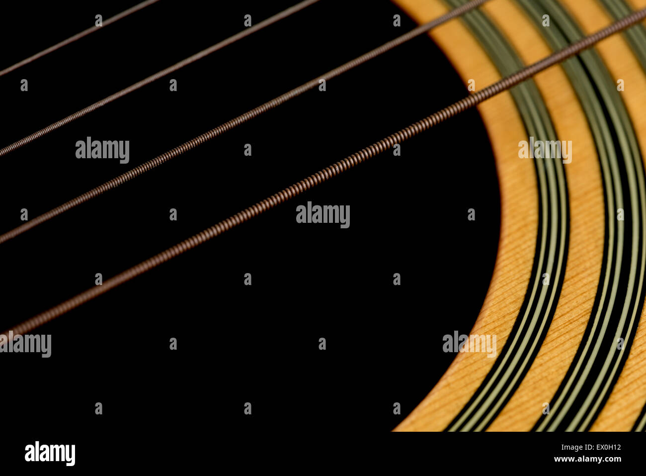 Un angolo di ripresa macro di chitarra acustica di stringhe e il legno intorno al foro del suono della chitarra. Foto Stock