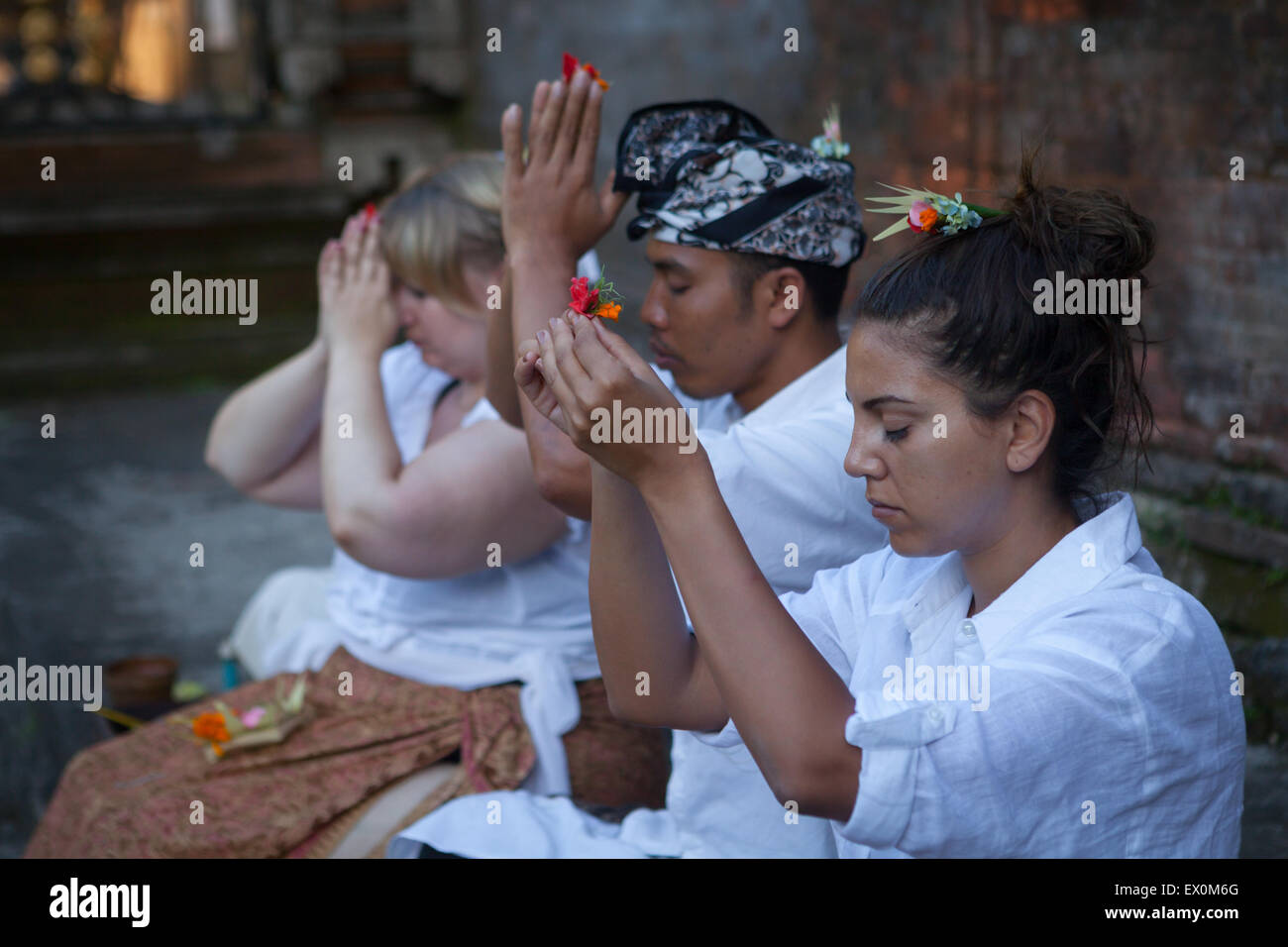 Donne occidentali che praticano la meditazione con guru balinese al tempio Tirta Empul a Tampaksiring, Bali, Indonesia. Foto Stock