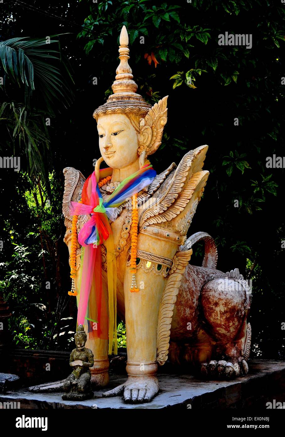 Chiang Mai, Thailandia: Statua di metà uomo e metà animale mitologico drappeggiati con colorati tessuti di collo e ghirlande di Wat Pala Foto Stock