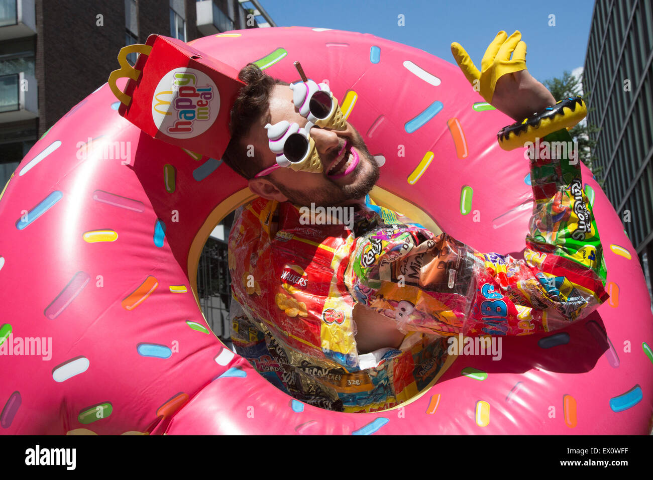 Performance di artista Antonio Gigliotta con un costume colorato all'orgoglio LGBT in London Parade. Foto Stock