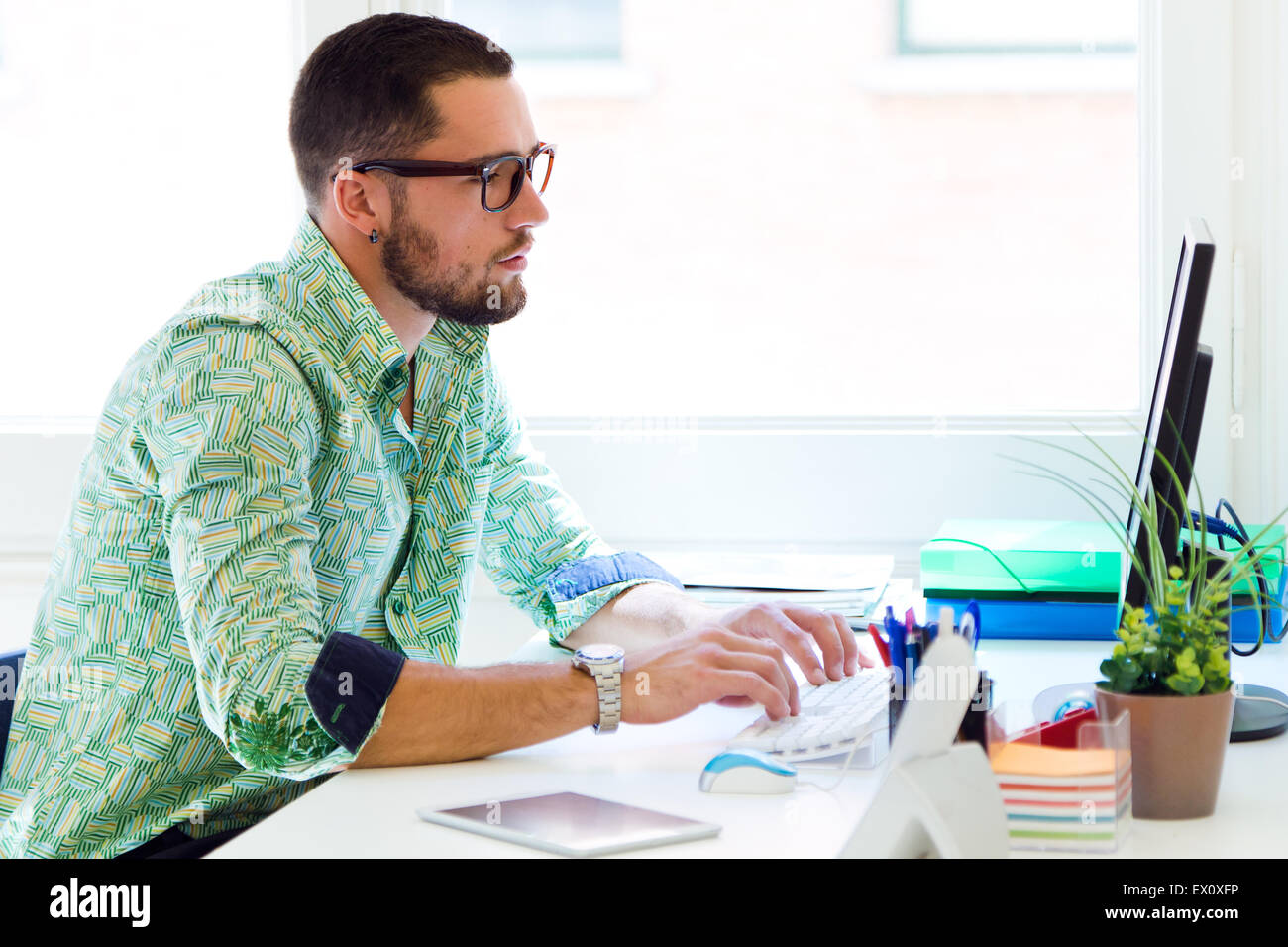 Ritratto di imprenditore bello lavorare con il computer portatile in ufficio. Foto Stock