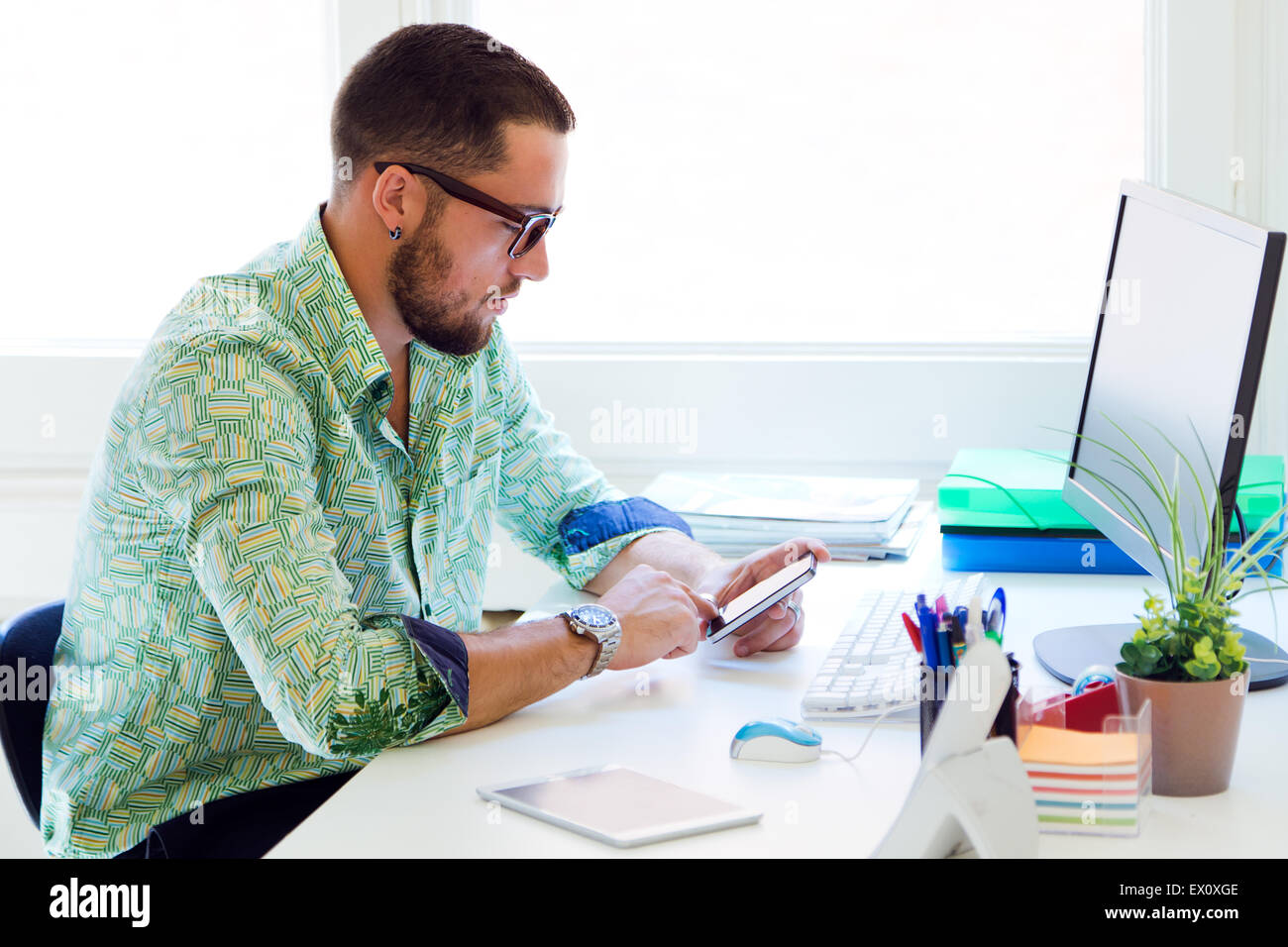 Ritratto di imprenditore bello lavorare con il computer portatile in ufficio. Foto Stock