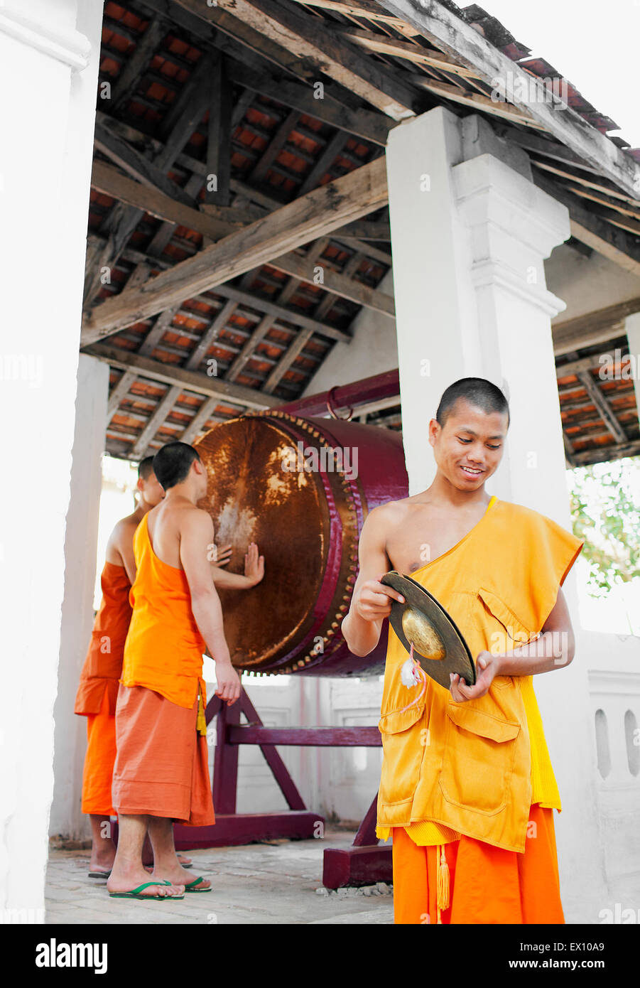 I monaci battere il tamburo a Iva Paphaimisaiyanaram al crepuscolo. Luang Prabang, Laos. Foto Stock