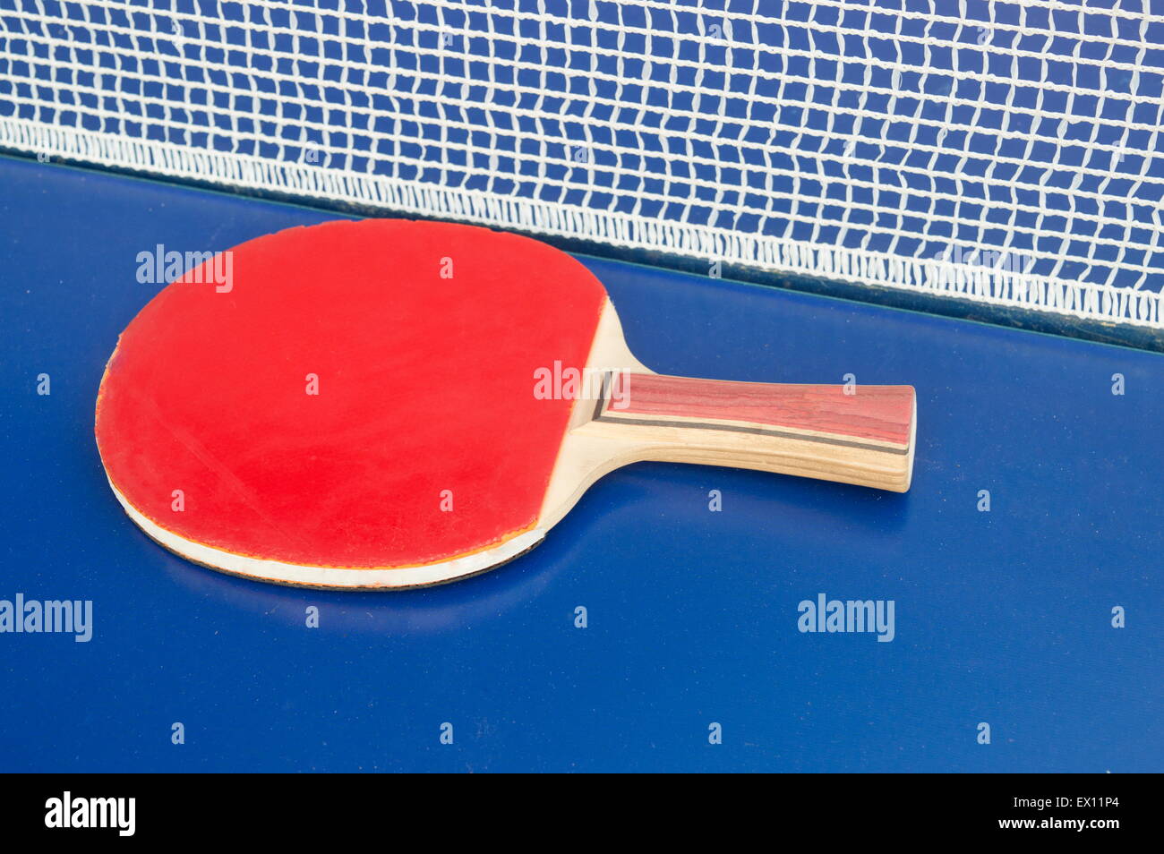 Tabella racchetta da tennis e net su un blu tavolo da ping pong Foto Stock