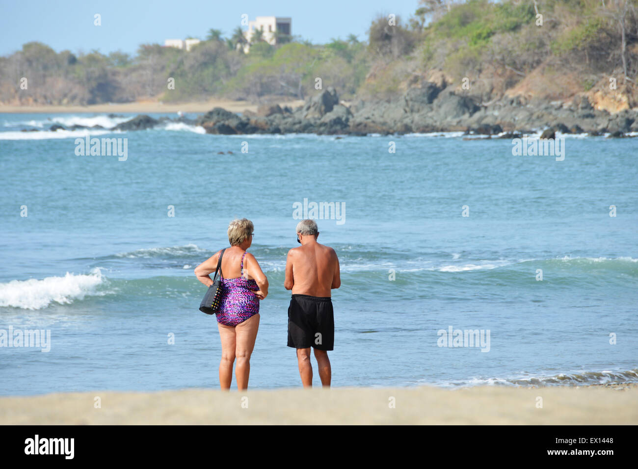Coppia di anziani di fronte ad una spiaggia tropicale Foto Stock