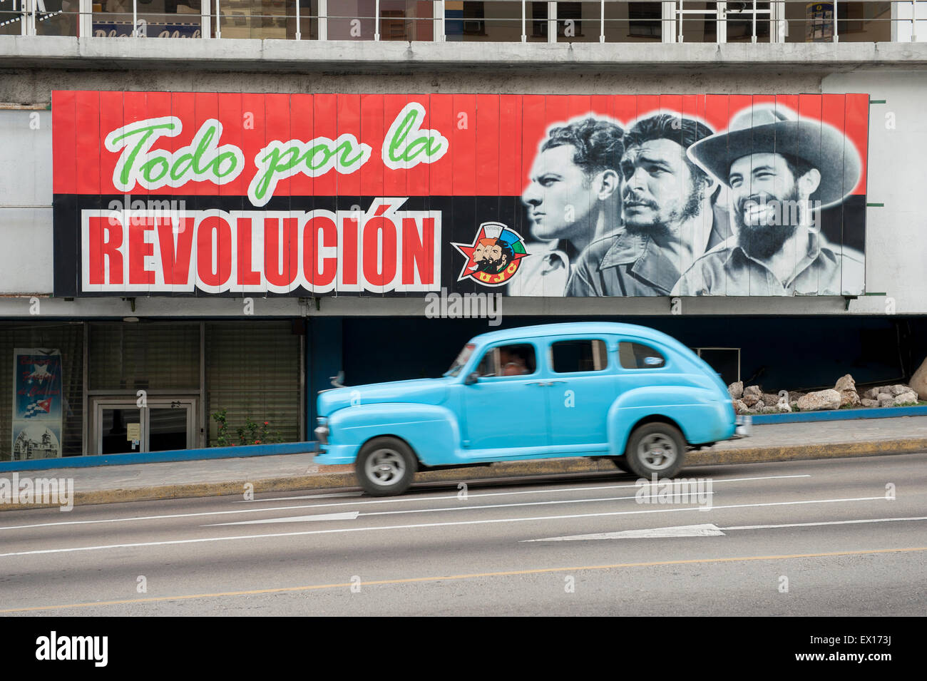 L'Avana, Cuba - Giugno, 2011: Vintage americano auto taxi passa al di sotto di billboard la promozione di propaganda comunista del La rampa area. Foto Stock