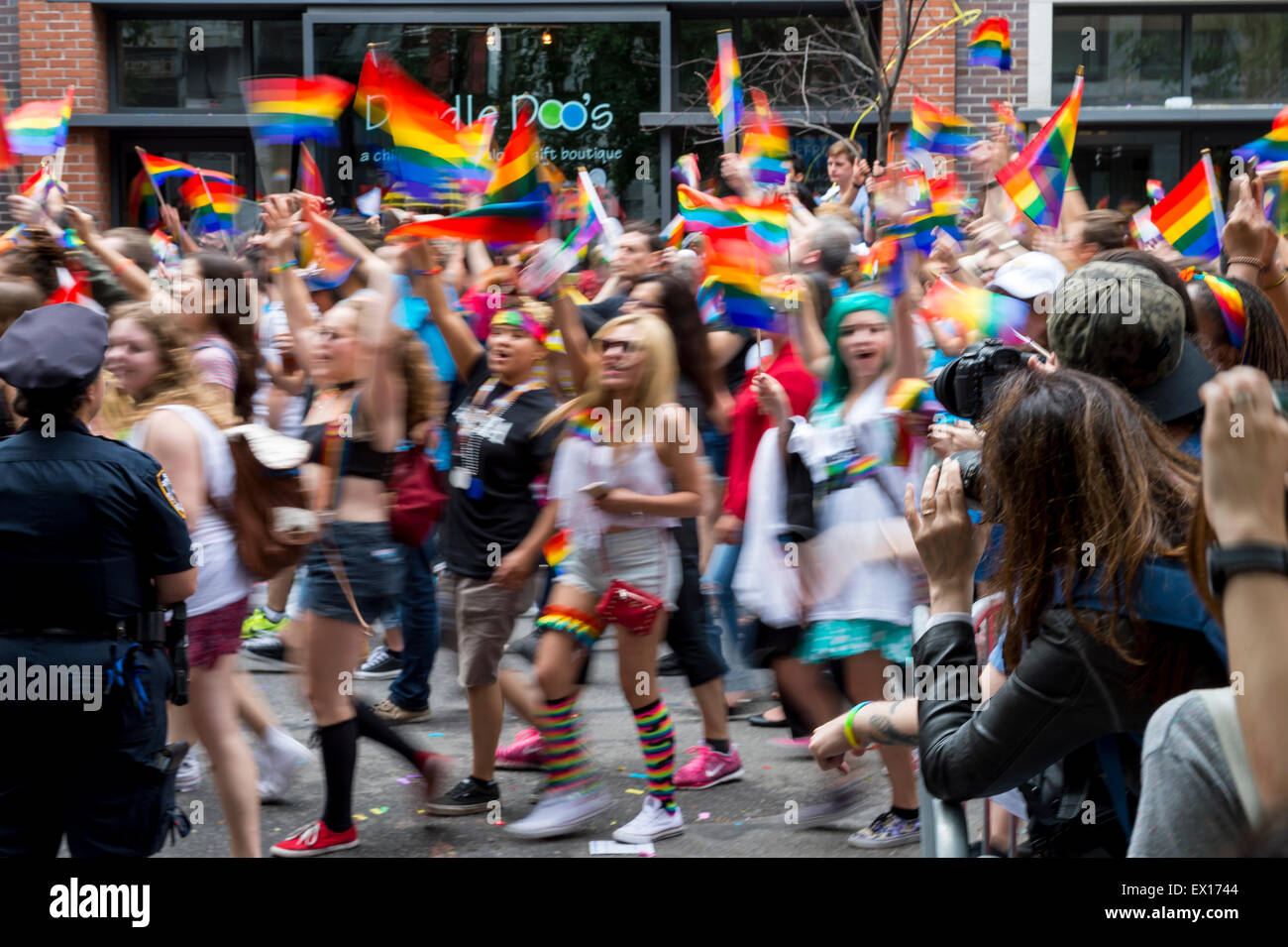 La città di NEW YORK, Stati Uniti d'America - 28 giugno 2015: celebranti all annuale Gay Pride Parade onda bandiere arcobaleno passando il tifo curiosi. Foto Stock