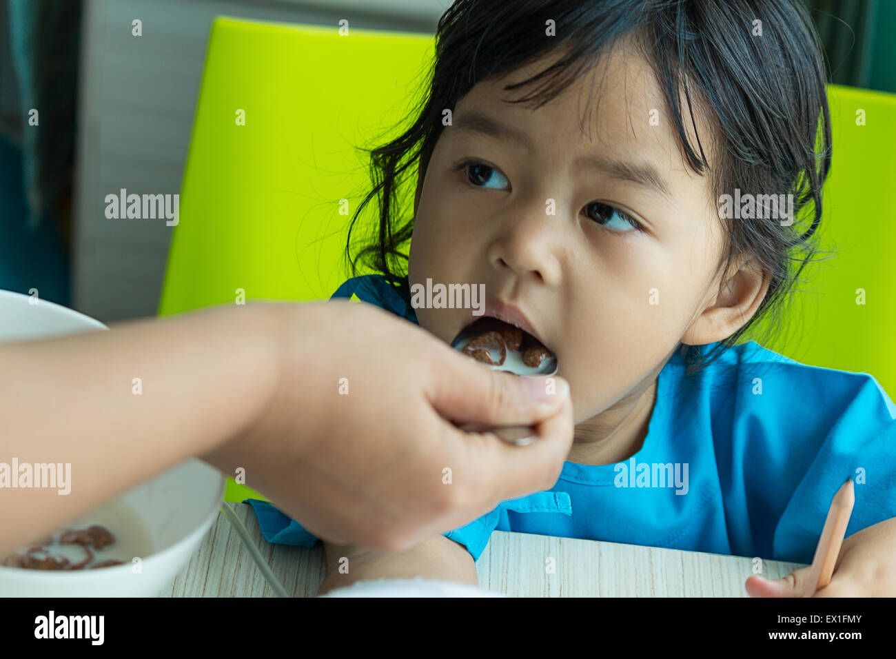 Malattia bambini asiatici carta da scrivere sulla scrivania e mangiare cereali, soluzione salina per via intravenosa (IV) a portata di mano Foto Stock