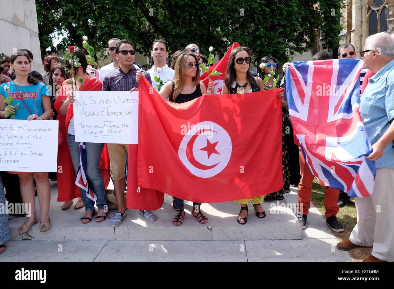 Un tunisino tenere un britannico e bandiere tunisino in un rally contro il terrorismo, London, Regno Unito Foto Stock