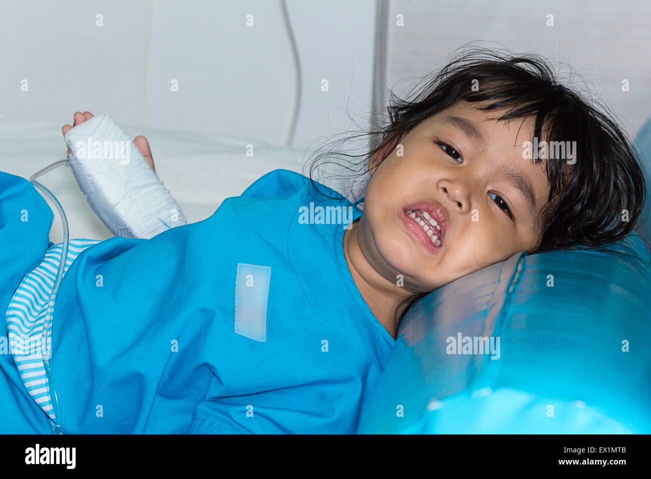 Malattia poco ragazzi asiatici gridare, addormentato su un sickbed in ospedale, soluzione salina per via intravenosa (IV) a portata di mano Foto Stock
