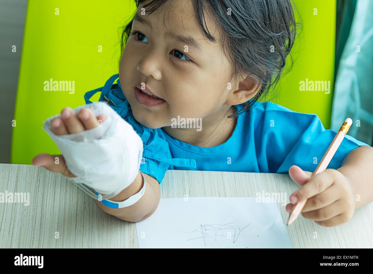 Malattia poco ragazzi asiatici carta da scrivere sulla scrivania in ospedale, soluzione salina per via intravenosa (IV) a portata di mano Foto Stock