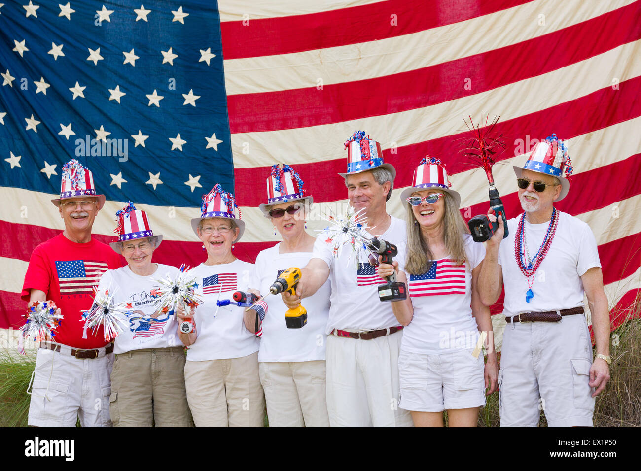 Carolina del Sud, Stati Uniti d'America. 4 Luglio, 2015. Membri del " Trapano di precisione Team' pongono di fronte a una bandiera americana durante l'I'sul quartiere Independence Day parade Luglio 4, 2015 in Mt Pleasant, Carolina del Sud. Il team parate utilizzando azionato a batteria trapani come loro novità. Foto Stock