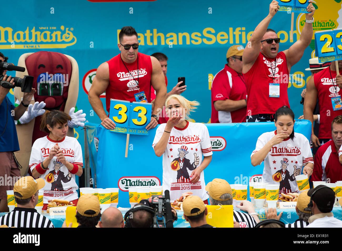 New York, Stati Uniti d'America. 4 Luglio, 2015. Michelle Lesco, Misi Sudo e Giulietta Lee (L a R) competere durante il 2015 Nathan il famoso quarto di luglio International Hot Dog-Eating Contest a Coney Island di New York City, Stati Uniti, dal 4 luglio 2015. In uomini della concorrenza, Matt Stonie Stonie mangiato 62 franchi e panini in dieci minuti, rottura della castagna offerta per una nona vittoria diritta. Nella donna della concorrenza, svoltasi il sabato mattina, Miki Sudo trattenuto il il titolo femminile da mangiare 38 hot dogs in dieci minuti. Credito: Li Muzi/Xinhua/Alamy Live News Foto Stock