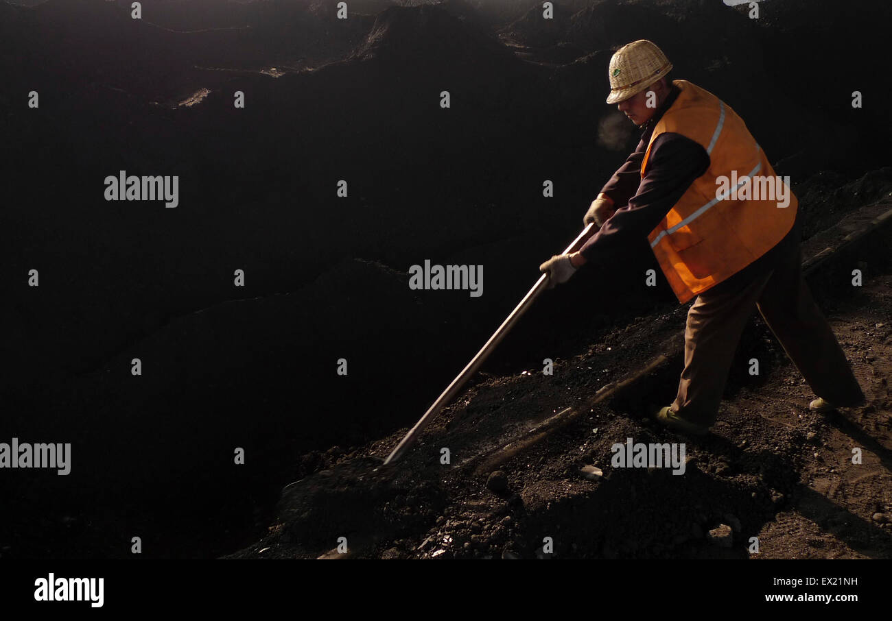 Un operaio lavora su un dump di carbone sito di una potenza termica impianto Xiangfan, provincia di Hubei il 6 gennaio 2010. Le scorte di carbone in Cina la m Foto Stock