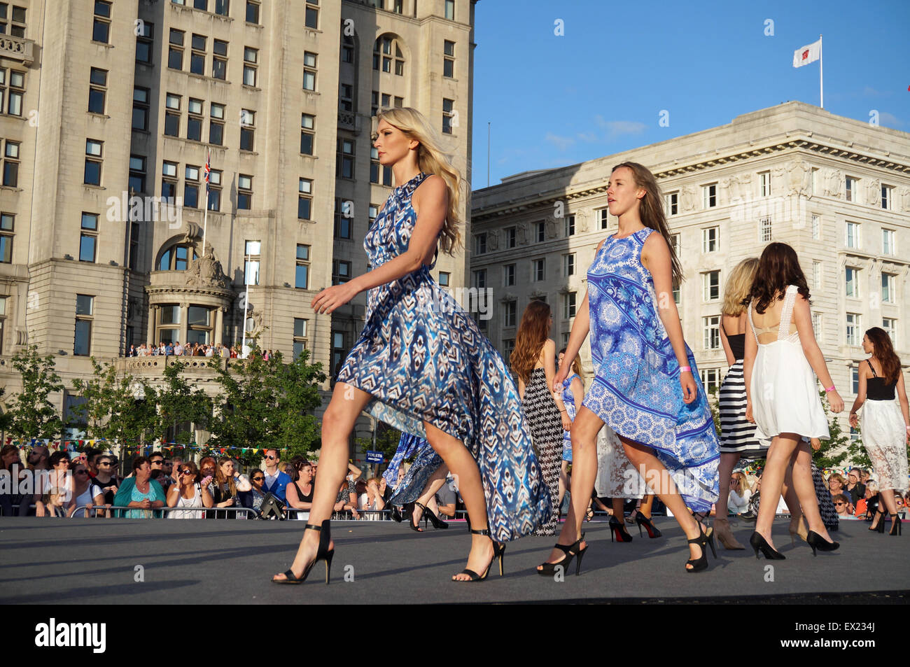 Liverpool, Regno Unito. 04 Luglio, 2015. Un nuovo Guinness World Record per la maggior parte delle persone modellazione su una passerella è stato rotto in Liverpool la sera di sabato 4 luglio, 2015. Il vecchio record era detenuto da Città del Messico con 3,083 persone - Liverpool è di nuovo record è stato 3,651 persone su una passerella. L'evento ha avuto luogo presso il Pier Head , Liverpool e fu visto da migliaia di persone sotto il sole con la Queen Mary 2 ormeggiato in background. Credito: Pak Hung Chan/Alamy Live News Foto Stock