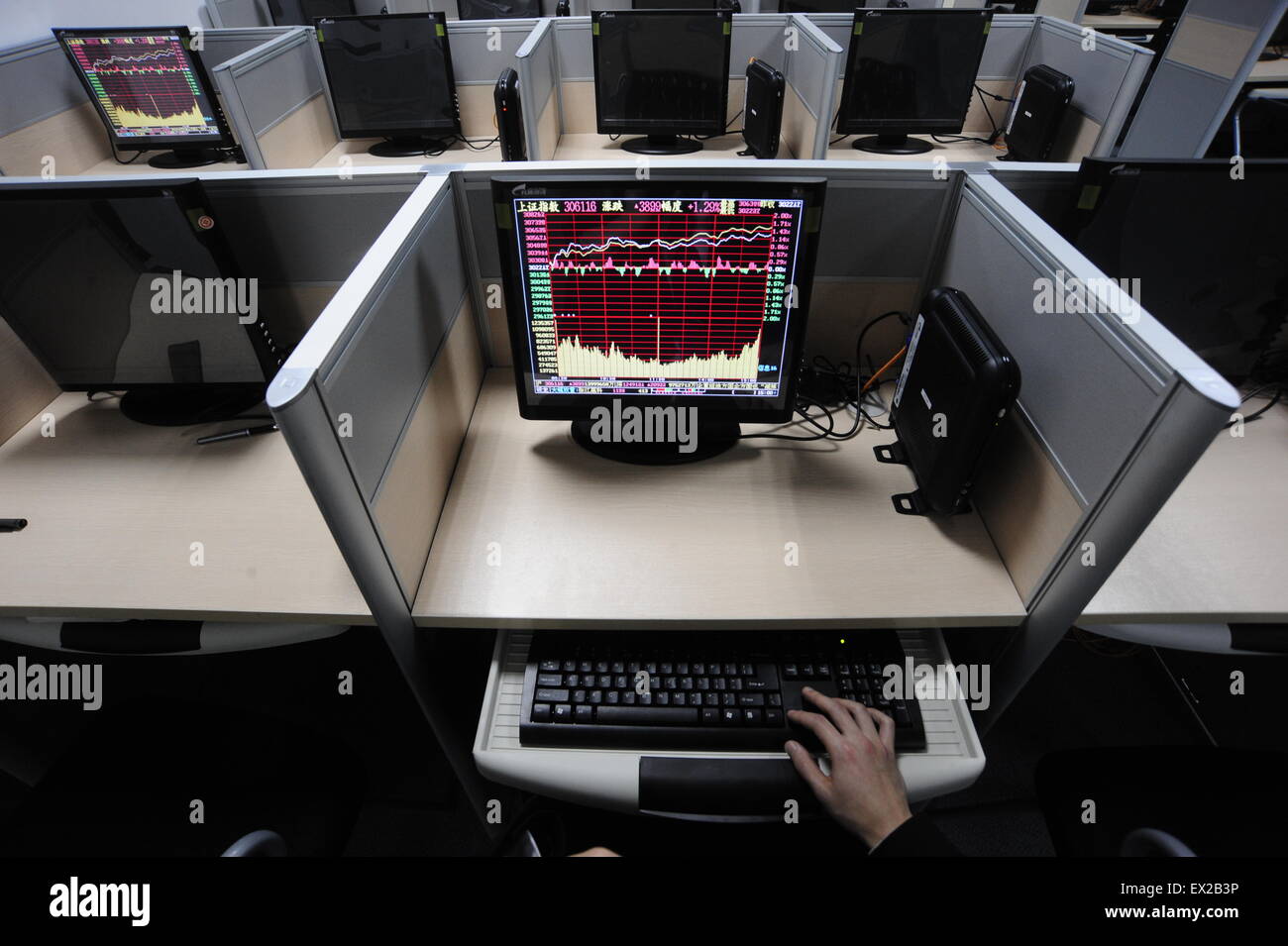 Un investitore di gesti di fronte a una schermata con informazioni di borsa presso una società di intermediazione mobiliare in Hefei, Anhui Provincia Febbraio 25, 201 Foto Stock