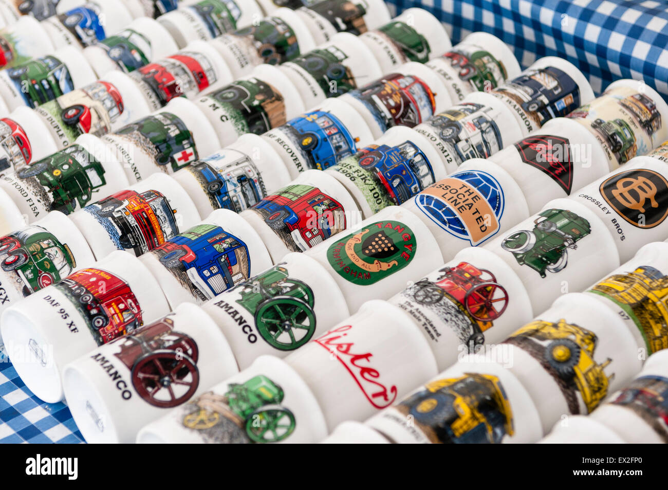 Tazze con foto dei veicoli, autobus, escavatori e trattori in vendita su un mercato in stallo Foto Stock