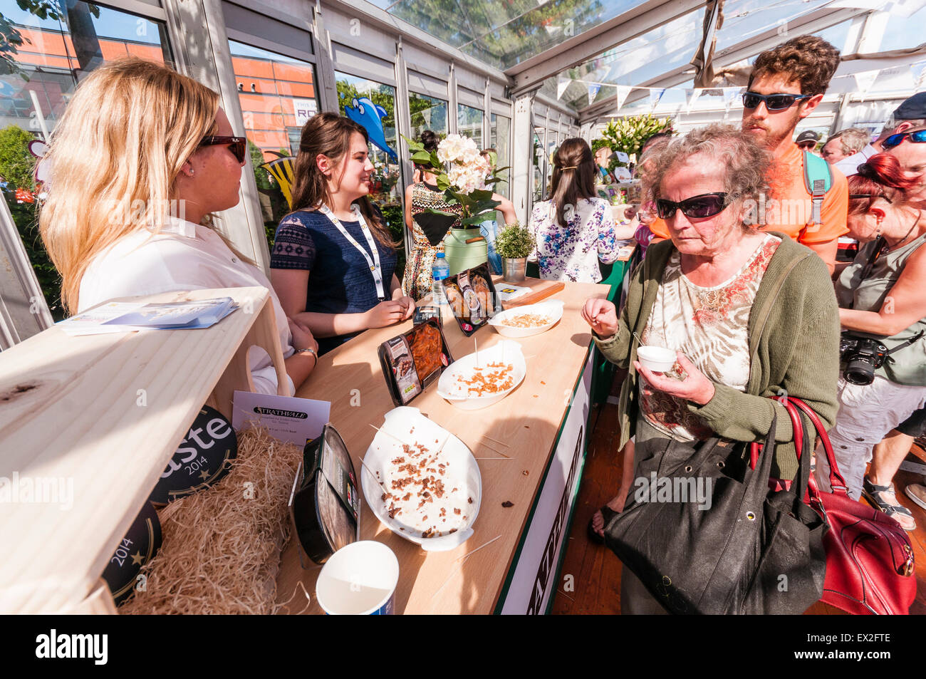 Le persone si radunano per provare a campioni a foodfair, ma solo sfridi restano Foto Stock