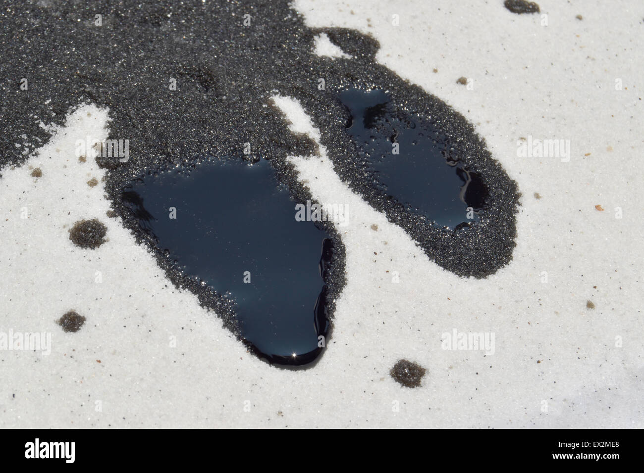 Fuoriuscita di olio sulla sabbia bianca Foto Stock